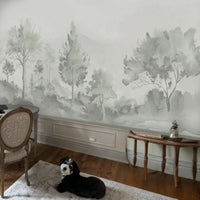 An architectural perspective of a luxury interior featuring the Minimalist Watercolour Tree Mural in Soft Sage Grey. The mural’s misty, receding landscape creates a sense of infinite horizon and organic calm, perfectly complementing minimalist furniture, natural wood accents, and soft, neutral upholstery.