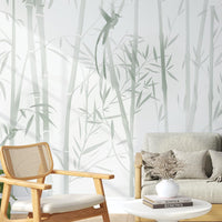 An architectural perspective of a contemporary sunlit lounge featuring the Mist Scenic Landscape Mural as a full-scale feature wall. The mural’s soft verdant tones pair elegantly with a light gray sofa, natural wood furniture, and woven rattan accents, creating a serene and sophisticated interior sanctuary.
