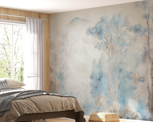 Misty blue ash watercolor forest mural wallpaper installed as a feature wall in living room, dining room, and bedroom interiors with soft blue and grey tones.