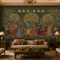 A luxurious living room features a large, wall-to-wall mural inspired by traditional Indian miniature art. At the center, Radha and Krishna stand together beneath a golden tree, surrounded by women in colorful lehengas carrying decorative pots. Intricate floral vines, birds, lotus flowers, and ornate borders frame the scene, with small seated sages depicted along the top. The room is furnished with carved wooden sofas and armchairs, cream upholstery, brass table décor, matching lamps, and a p