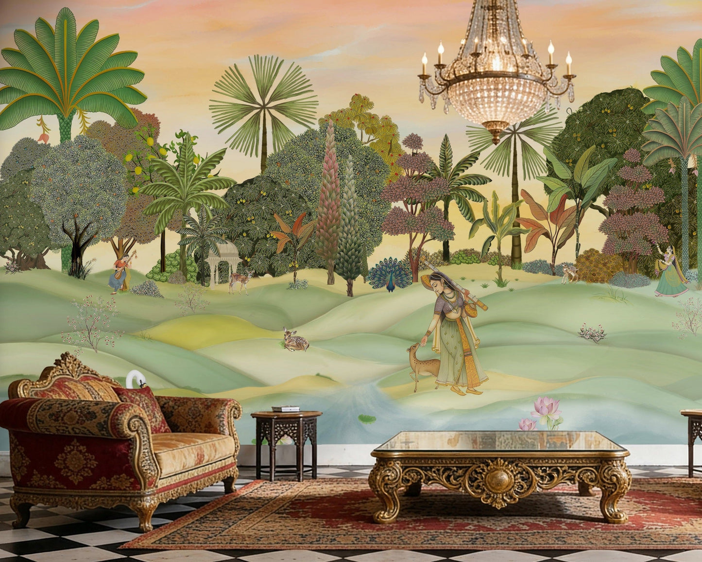 A panoramic Pichwai wallpaper mural featuring a divine Vrindavan Garden scene with hand-painted peacocks, spotted deer, and traditional figures. The design showcases lush tropical trees and a sunset-hued sky, bringing a royal Indian heritage aesthetic to a luxury living room.