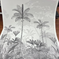 An architectural perspective of a high-ceilinged contemporary lounge featuring the Paradise Palms Mural in Ivory White as a full-scale feature wall. The mural’s expansive botanical vista pairs elegantly with light-toned furniture and organic textures, creating a peaceful and cultured interior sanctuary.