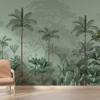 An architectural perspective of a high-ceilinged contemporary lounge featuring the Paradise Palms Mural in Sage Green as a full-scale feature wall. The mural’s expansive botanical vista pairs elegantly with mid-century modern furniture and natural sunlight, creating a peaceful and cultured interior sanctuary.