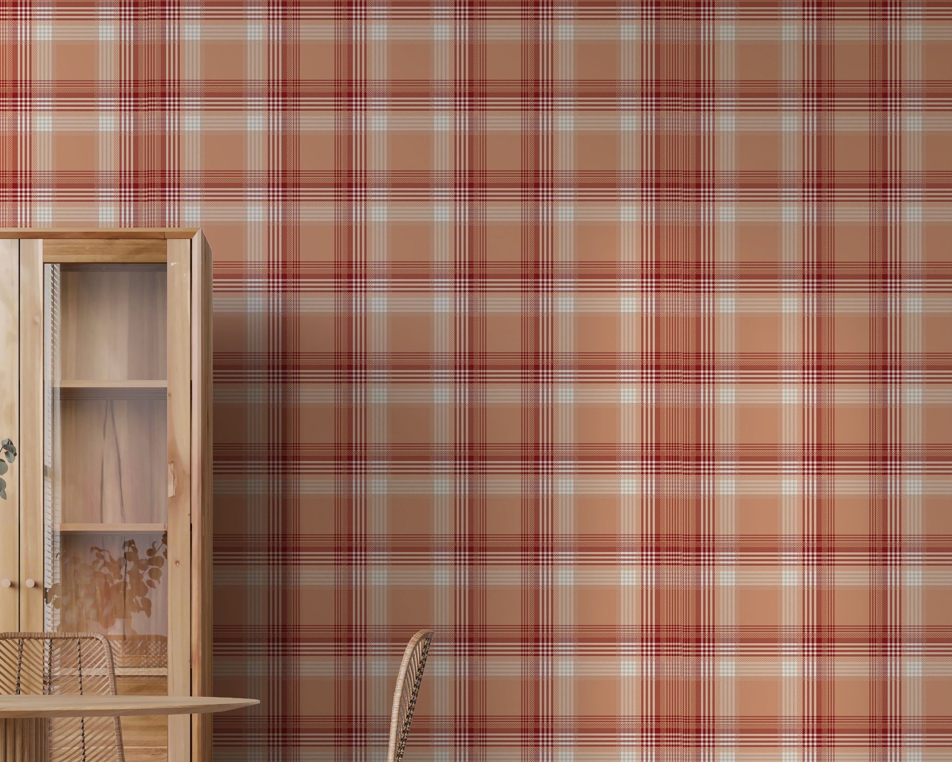 A modern dining area featuring a vibrant cinnamon-blush orange and red plaid wallpaper. On the left stands a tall, light wood display cabinet with glass doors, next to a round wooden dining table with a fluted pedestal base. Woven rattan dining chairs with slim black metal legs are arranged around the table, and a white vase filled with eucalyptus branches rests on top. The room features light-colored vertical wood plank flooring.