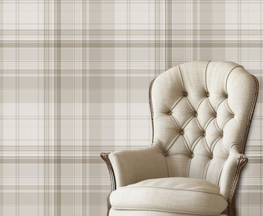 A classic interior scene featuring a beige tufted armchair with dark wooden legs placed against a neutral plaid wallpaper in soft taupe and cream tones. The room has white painted wood flooring and a calm, elegant aesthetic.