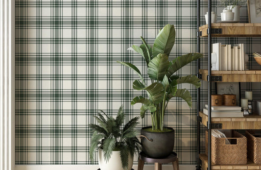 A modern room features a crisp white and forest green plaid wallpaper.
The detailed pattern shows intersecting dark green lines crossing over a light base.
In front, two vibrant green potted plants sit nicely on small stands.
A tall, industrial-style wooden shelving unit completes the organized corner setup.