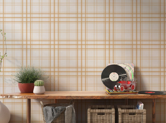 A stylish living area features a warm golden yellow and white plaid wallpaper.
The detailed design shows thin white lines intersecting to form clean grids across a yellow base.
In front, a cream-colored wooden sideboard with woven rattan doors is centered nicely.
The bright setup is accented with a white desk lamp, pottery, and a leafy green plant.
