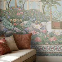 Radha Madhav heritage wall mural in a luxury Indian living room with carved wooden sofas, patterned cushions, brass décor, and traditional rugs.