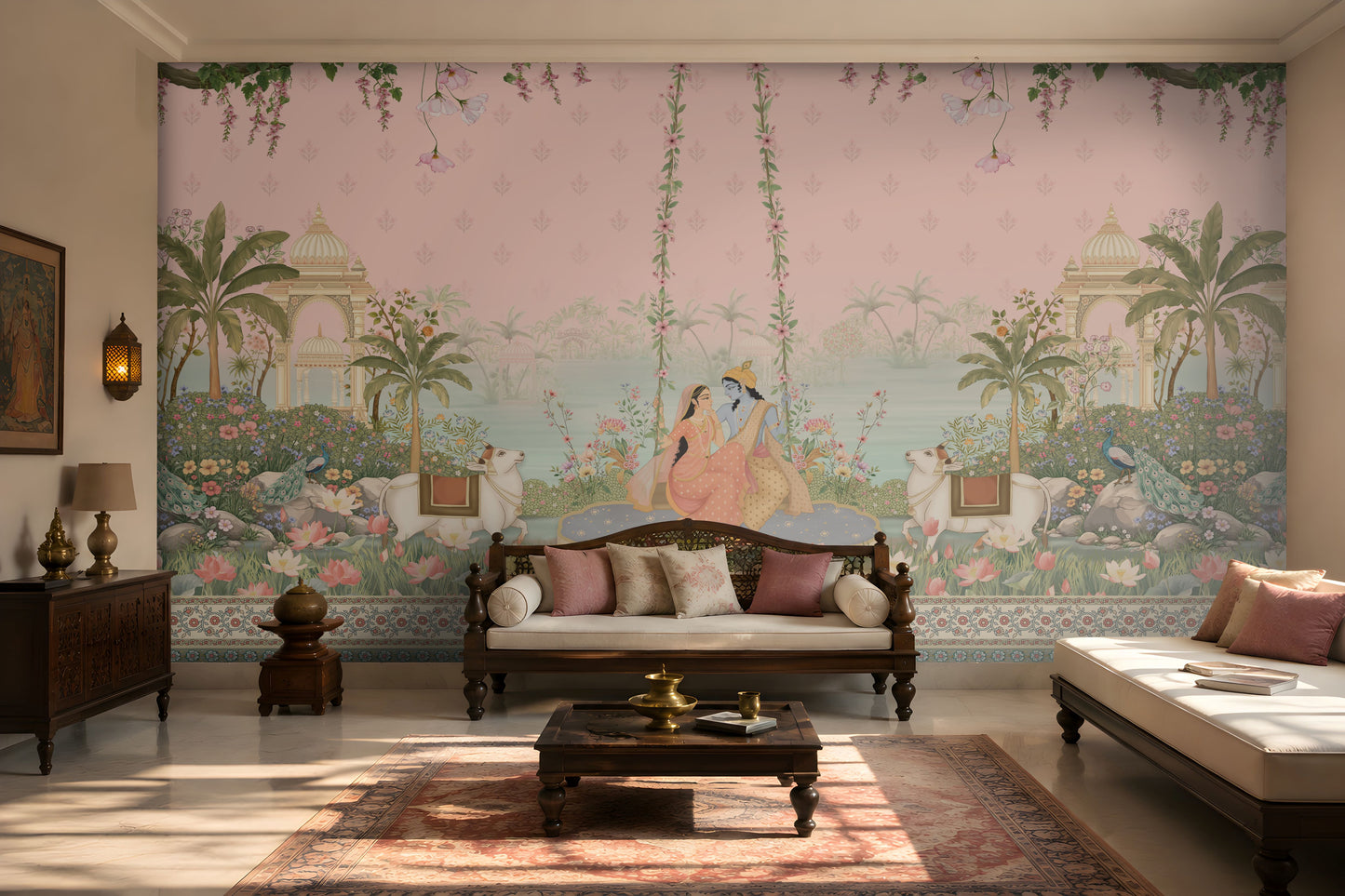 Radha Madhav pink heritage wall mural in a luxury Indian living room with carved wooden seating, floral cushions, brass décor, and traditional rug.