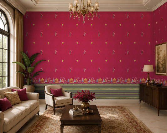 Elegant living room featuring a vibrant fuchsia accent wall adorned with small repeating traditional motifs and an ornate architectural border along the base. The space includes cream upholstered seating with magenta accent cushions, a dark wood coffee table with a floral arrangement, a patterned area rug, and a brass chandelier overhead. Large arched windows and warm natural light complement the rich colors and create a sophisticated, Indian-inspired interior.