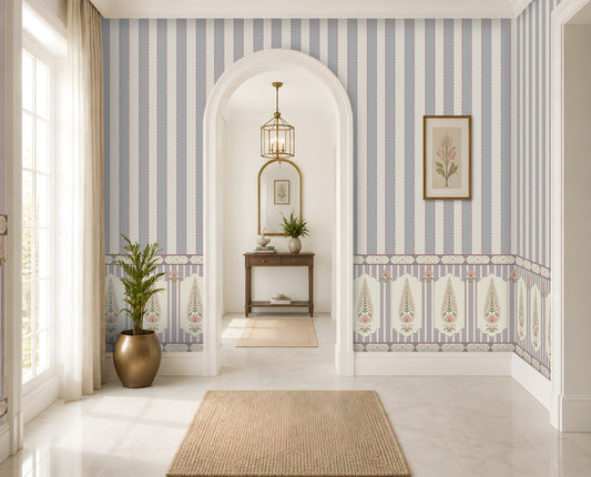 A beautifully styled interior hallway featuring light blue and white vertical striped wallpaper with a decorative border, white walls, a beige woven rug, a potted plant, and an arched doorway in the background.