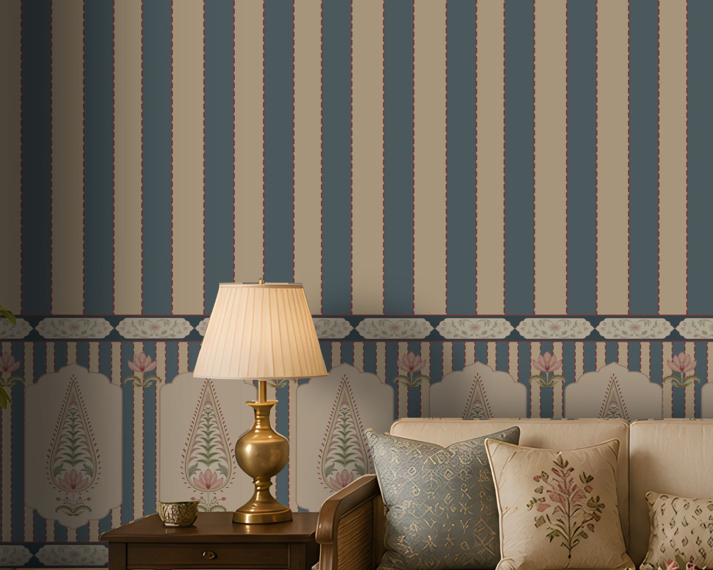 A styled interior scene showing a cream sofa with patterned pillows, a brass table lamp on a wooden side table, and a wall covered in blue and beige vertical striped wallpaper with a decorative border.