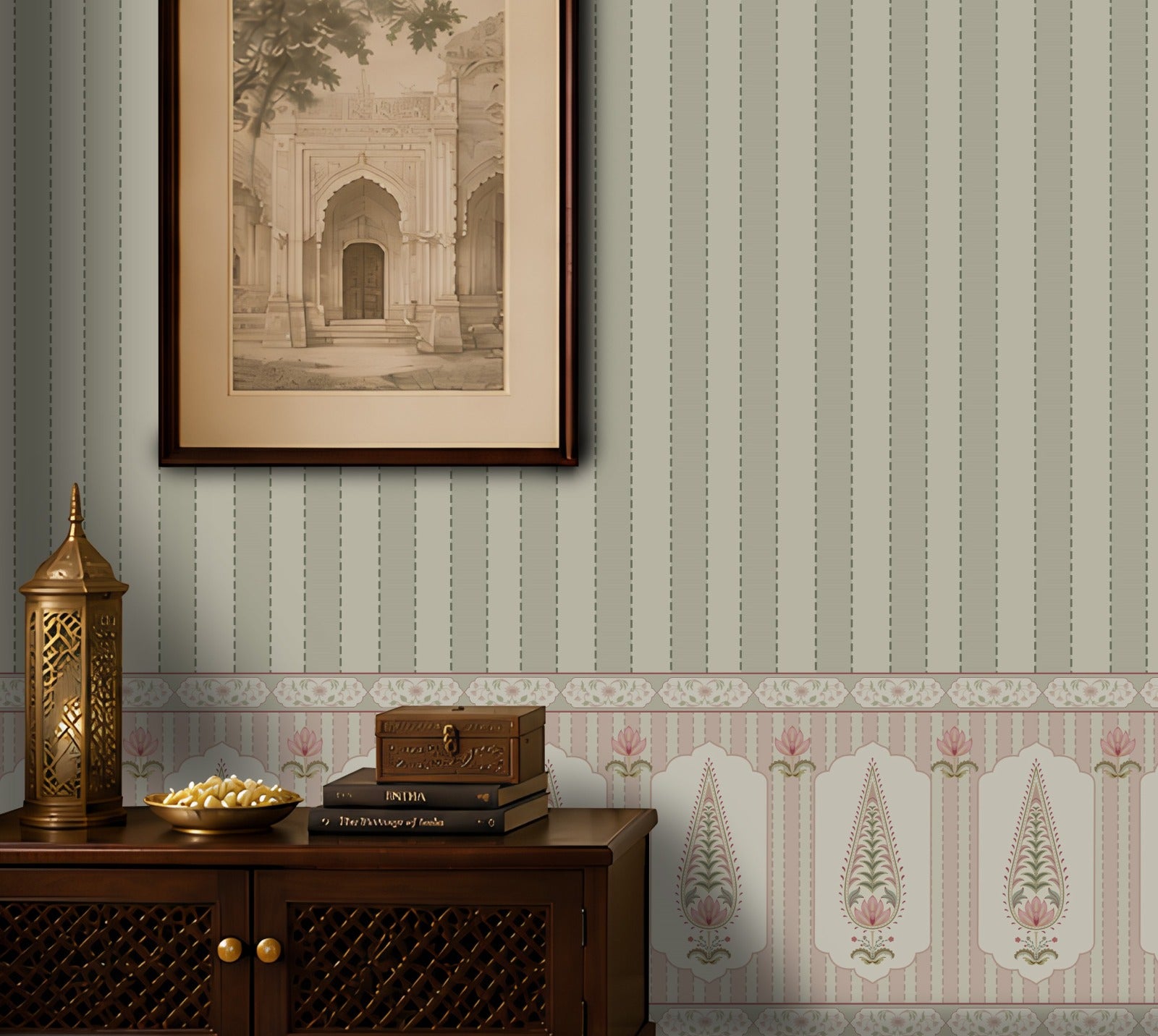 A styled interior scene showing a wall with vertical striped wallpaper in muted sage green, blush pink, and cream, plus a decorative border. A dark wood cabinet sits along the bottom with a brass lantern, a bowl of gold coins, stacked books, and a framed sepia architectural print hanging above.