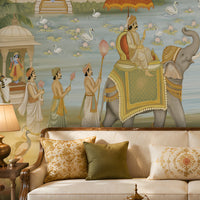 Luxurious traditional living room with an ornate chandelier, cream sofa and carved wooden armchairs, centered around a large mural depicting elephants, peacocks, lotus flowers, and an ornate Indian-inspired palace landscape.