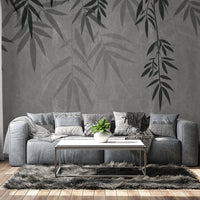 An architectural perspective of a contemporary lounge featuring the Sasa Leaves Mural in Granite Gray as a full-scale feature wall. The mural’s cool, stone-like tones pair elegantly with gray velvet upholstery, natural wood flooring, and industrial-style shelving, creating a balanced and cultured interior sanctuary.