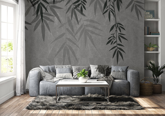 An architectural perspective of a contemporary lounge featuring the Sasa Leaves Mural in Granite Gray as a full-scale feature wall. The mural’s cool, stone-like tones pair elegantly with gray velvet upholstery, natural wood flooring, and industrial-style shelving, creating a balanced and cultured interior sanctuary.