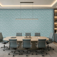 A modern conference room with a large oval wooden table, eight gray office chairs, a light blue patterned accent wall, and built-in shelving on the right side.