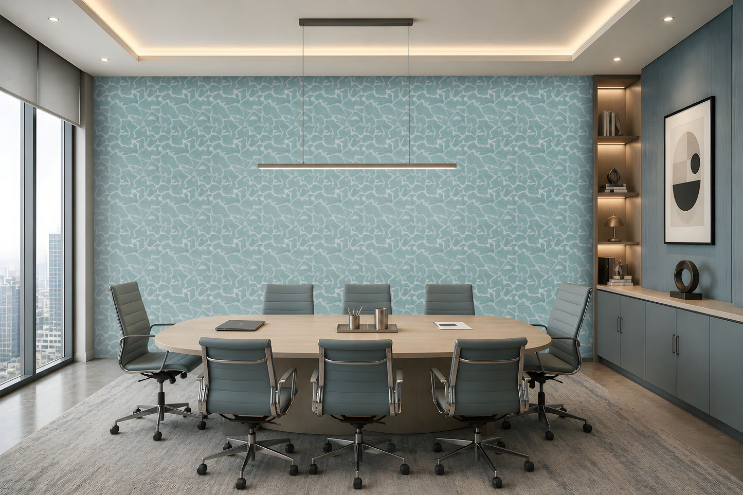 A modern conference room with a large oval wooden table, eight gray office chairs, a light blue patterned accent wall, and built-in shelving on the right side.