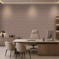 A modern office interior featuring a large desk, two beige chairs, a computer monitor, shelving, and a wall covered in a pink and beige abstract patterned wallpaper.