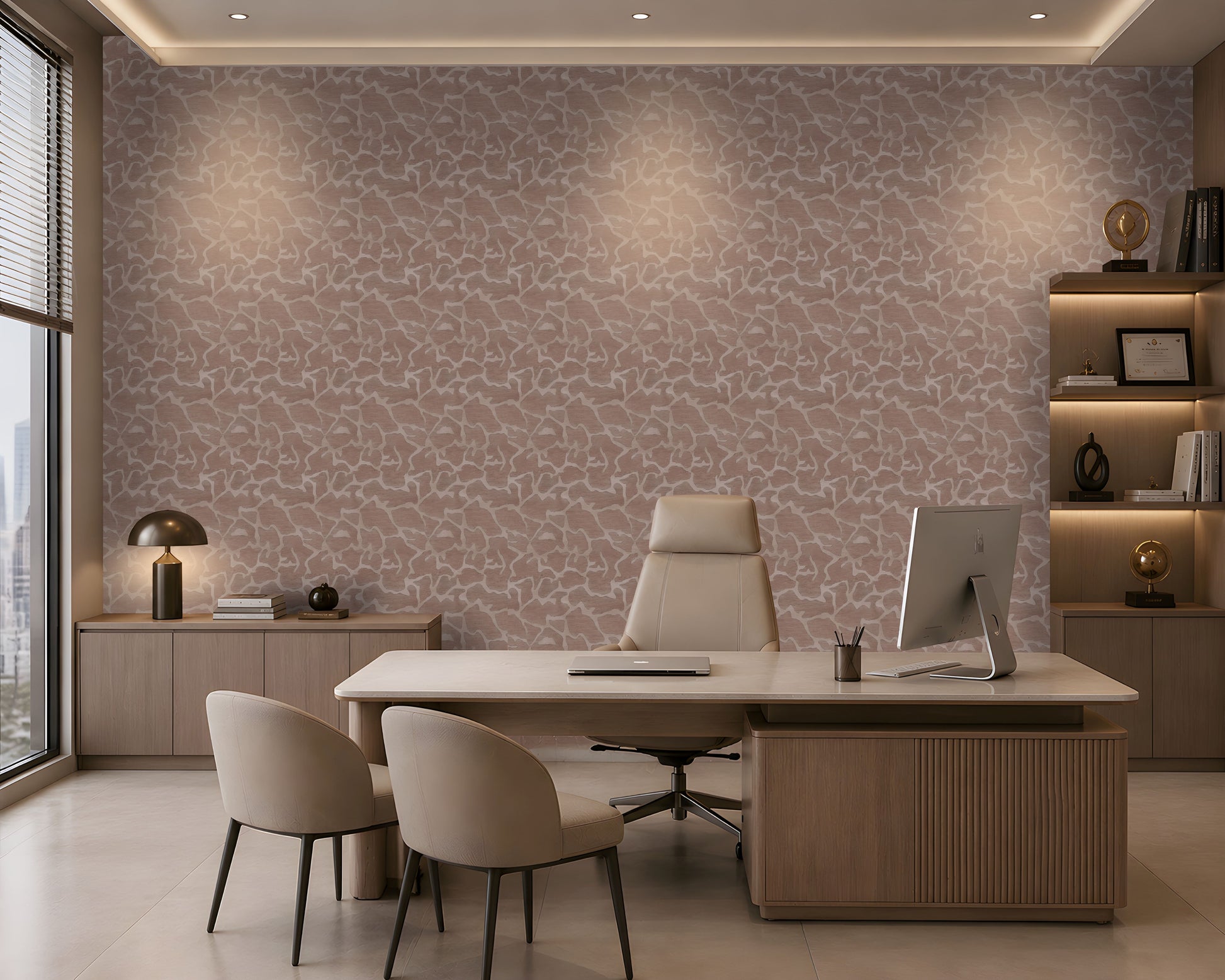 A modern office interior featuring a large desk, two beige chairs, a computer monitor, shelving, and a wall covered in a pink and beige abstract patterned wallpaper.