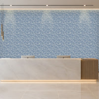 A modern reception desk in a bright, contemporary office lobby. The desk features a white marble top with a vertical slatted wood side panel and a warm under-glow.