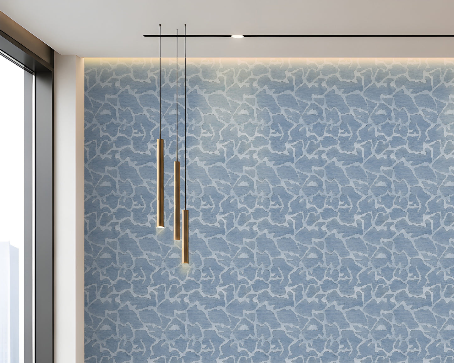 A modern interior wall featuring a blue and white abstract crackle pattern, with three hanging cylindrical pendant lights and a linear ceiling light above.