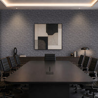 A modern conference room with a long dark wood table, black office chairs, a patterned gray wall, and a framed abstract geometric painting in the center.