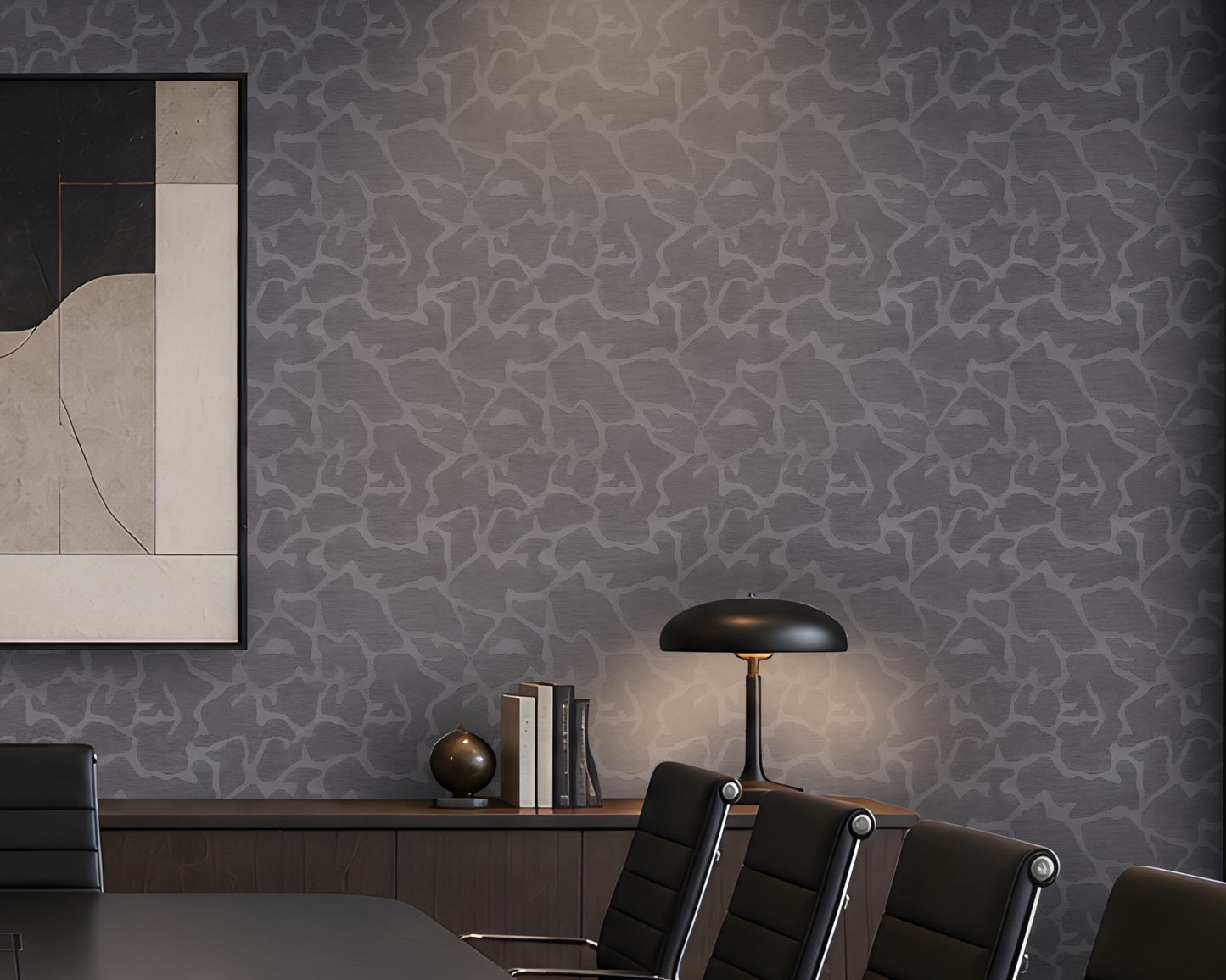 A styled interior room featuring textured gray wallpaper with a light organic crackle pattern, a dark wood credenza, a black table lamp, black office chairs, and a framed abstract art print.
