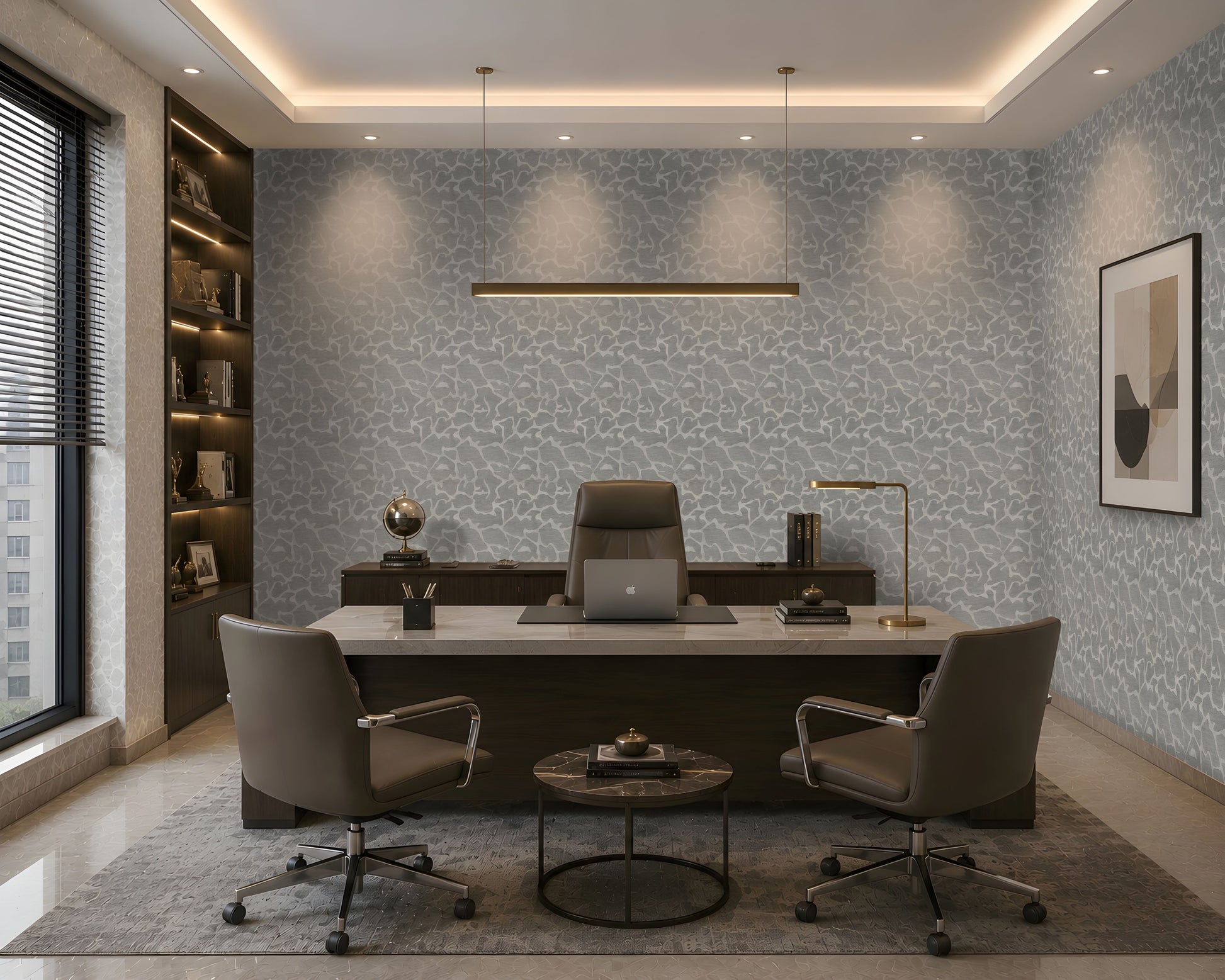 A modern office interior with a large desk, two gray office chairs, a round coffee table, built-in shelving, and patterned wallpaper on the back wall.