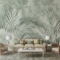 An architectural perspective of a high-end contemporary executive lounge featuring the Shaded Palmscape Mural in Sage Green as a full-scale feature wall. The mural’s cool, deep tones pair elegantly with dark metal accents, mid-century furniture, and polished stone flooring, creating a serene and cultured interior sanctuary.