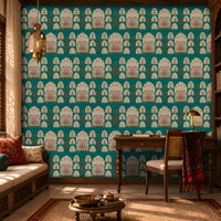 Shriji Darbar Heritage Wallpaper in Aqua blue featuring traditional Indian palace arches, royal darbar illustrations, ornamental motifs, and elegant cypress trees in a seamless repeating pattern, showcased in a refined study room with carved wooden furniture, brass lighting, bookshelves, and warm natural sunlight.