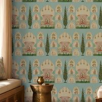 Shriji Darbar Heritage Wallpaper in soft sky aqua blue featuring traditional Indian palace arches, royal court scenes, ornamental motifs, and elegant cypress trees in a seamless repeating pattern, showcased in a sophisticated living room with carved wooden furniture, brass accents, and warm natural light.