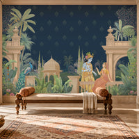 A large wall mural featuring a Kalka Kingdom scene with Krishna and Radha, styled in a traditional Indian room with a wooden bench, patterned rug, and carved wooden furniture.