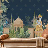 A large wall mural featuring a Kalka Kingdom scene with Krishna and Radha, styled in a traditional Indian room with a wooden bench, patterned rug, and carved wooden furniture.