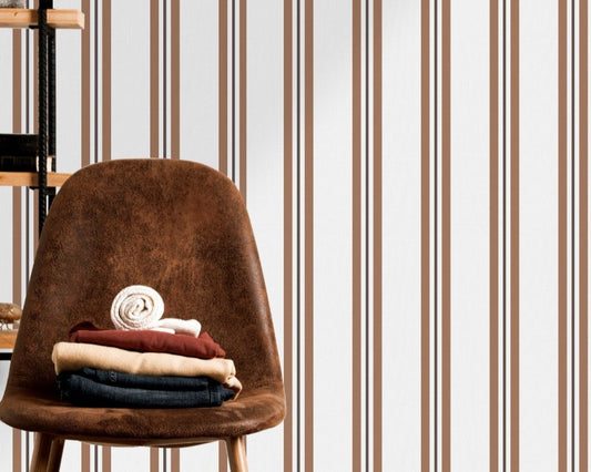 A warm dining area features a soft brown and white striped wallpaper.
The clean design shows vertical light brown lines repeating across a cream base.
In front, a sleek dark wooden table is paired with minimalist black chairs.
The sophisticated setup is completed by a contemporary black pendant light hanging above.