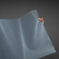 An architectural perspective of a high-traffic interior featuring Soft Steel Blue Wallcovering. The distant view illustrates how the linear-weave texture creates a seamless, professional backdrop with a calm, mineral-inspired glow that effectively masks wall surface irregularities.