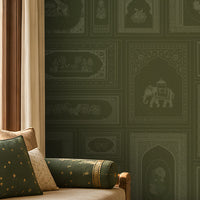 The Royal Rajputana Courtyard wallpaper in Heritage Moss Green featuring intricate Rajasthani palace-inspired motifs, elephant illustrations, floral panels, Mughal arches, and antique detailing in a luxurious traditional living room.
