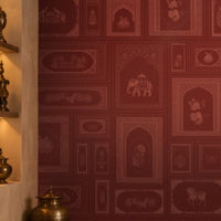 The Royal Rajputana Courtyard wallpaper in Heritage Ruby Red featuring intricate Rajasthani palace-inspired motifs, elephant illustrations, floral artwork, Mughal arches, and tonal heritage patterns in a luxurious royal-inspired interior.