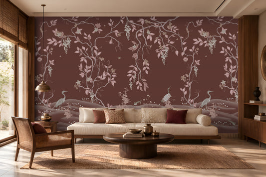 Timeless Avian Garden Mural in rich burgundy brown featuring delicate pink botanical branches, graceful birds, soft floral details, and flowing foliage. The elegant nature-inspired wallpaper creates a warm and sophisticated living room with neutral seating, dark wood furniture, natural textures, and soft ambient lighting.
