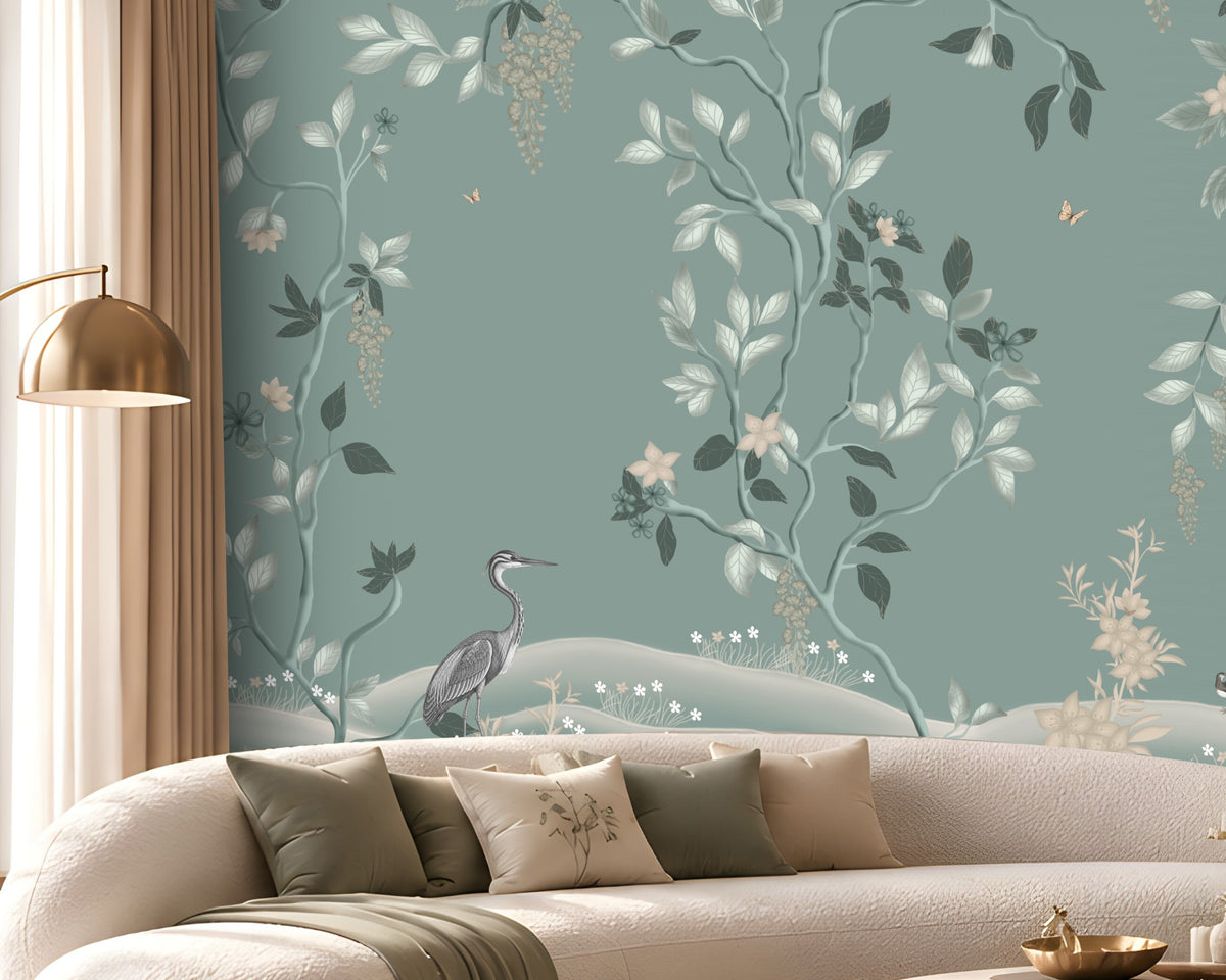 Timeless Avian Garden Mural in Misty Blue featuring delicate botanical branches, soft ivory flowers, graceful foliage, and elegant bird illustrations, creating a serene nature-inspired living room with a sophisticated misty blue and neutral colour palette, curved furniture, warm lighting, and contemporary décor.

