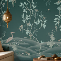 Luxurious living room featuring a teal botanical wallpaper mural with delicate vines, foliage, blossoms, and graceful birds, complemented by a neutral sofa, wooden coffee table, textured rug, warm pendant lighting, and elegant wooden cabinetry.
