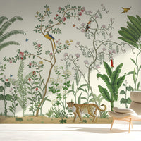 An architectural perspective of a sophisticated lounge featuring the Tropical Jungle Haven Mural in Sandy Beige as a full-scale feature wall. The mural’s detailed wildlife narrative pairs elegantly with warm wood tones and gold accents, creating a grand and sun-drenched interior sanctuary.