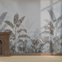 An architectural perspective of a refined room featuring the Silver Mist Tropical Leaf Mural as a full-scale feature wall behind a classic wooden fireplace mantel. The mural’s atmospheric depth and cool tones create a modern, immersive backdrop that pairs beautifully with natural wood flooring and light-filled spaces.