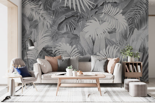 An architectural perspective of a high-end contemporary lounge featuring the Tropical Leaves Mural in Cloudy Gray as a full-scale feature wall. The mural’s atmospheric tones pair perfectly with dark wood furniture, velvet upholstery, and brushed metal accents, creating a peaceful and cultured interior sanctuary.