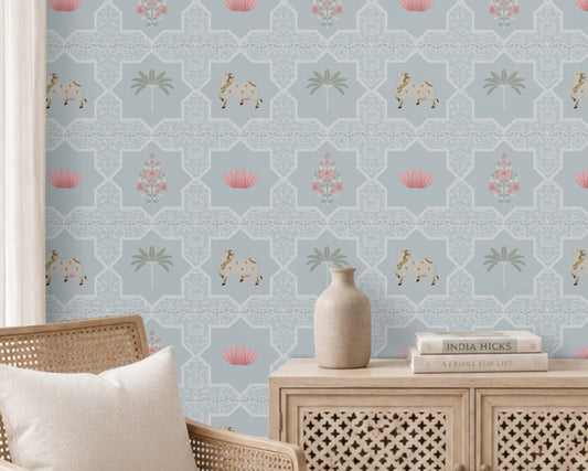 Close-up view of the Vraj Kamal wallpaper showcasing the intricate geometric damask lattice pattern, detailed white Pichwai cows, and delicate pink lotus flower motifs on a soft powder blue background.