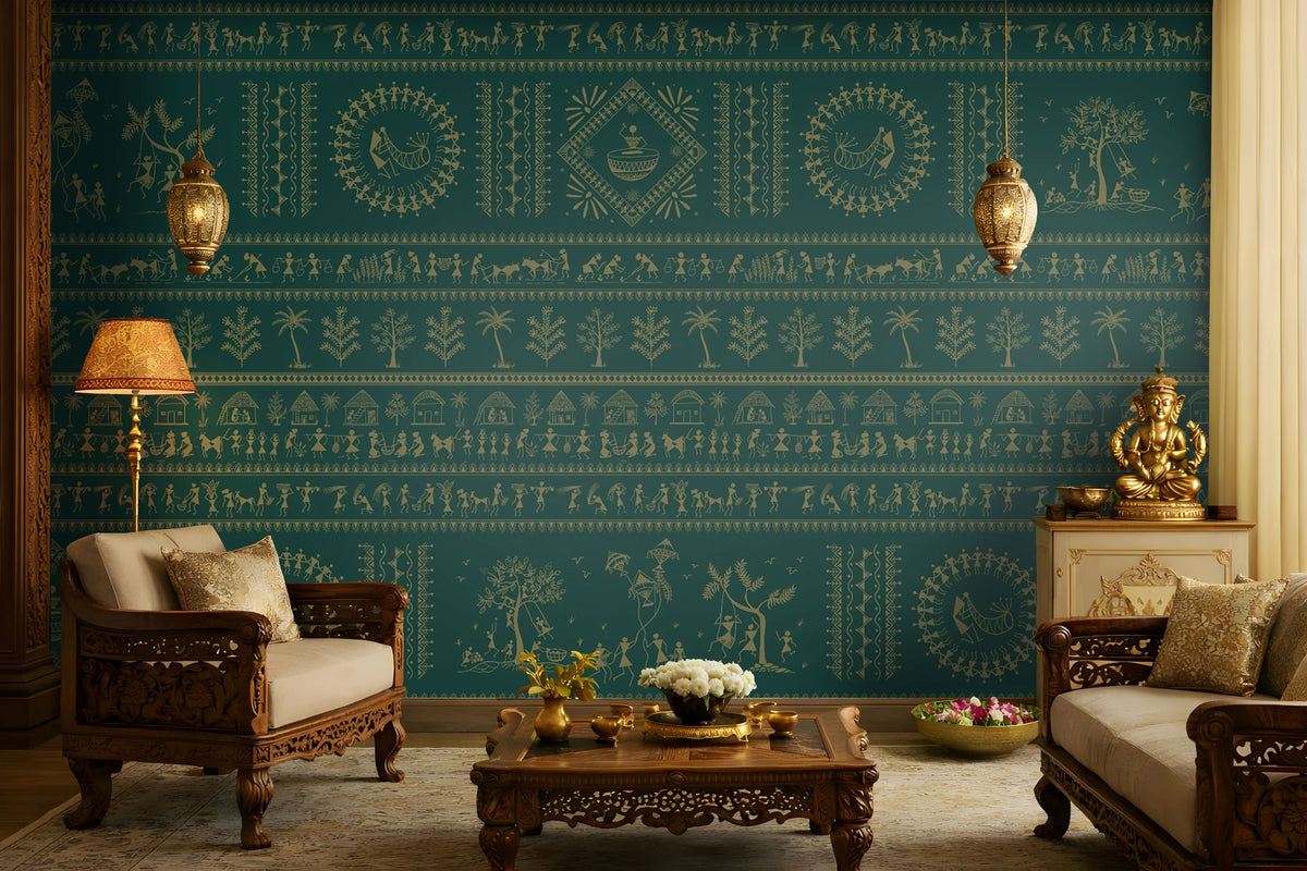 A traditional Indian living room titled “Warli Folk Tales – Vintage Teal Green.” The focal wall is painted in a deep teal shade and adorned with golden Warli tribal art depicting village life, dancing figures, huts, and trees in horizontal bands. Two intricately carved wooden armchairs with cushions flank a central coffee table decorated with brass items and a bowl of white flowers. Hanging brass pendant lamps and a golden table lamp cast a warm glow. 