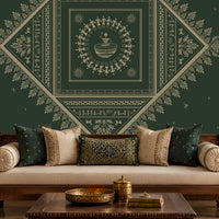 A styled living room featuring a large dark green wall mural with intricate cream-colored traditional geometric and floral patterns. In front of the wall is a wooden sofa with cream cushions, a dark wood coffee table, and a matching armchair.