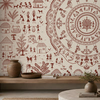 A styled interior scene featuring a large wall mural with a reddish-brown tribal folk art design on a warm cream background. The mural depicts a large circular mandala on the right and various figures, huts, and plants on the left.