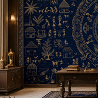 A large wall mural or wallpaper featuring an intricate navy blue and gold traditional circular mandala design with figures, houses, and trees, shown in a styled study with a wooden desk, chair, and sofa.