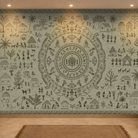 A large wall mural featuring an intricate circular mandala and folk-art style illustration in dark gray on a pale blue-green background, displayed in a modern living room setting with a sofa, wooden furniture, and a rug.